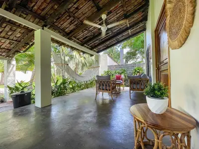 a patio with chairs and a table and some plants at Casa De Playa El Encanto in El Porvenir