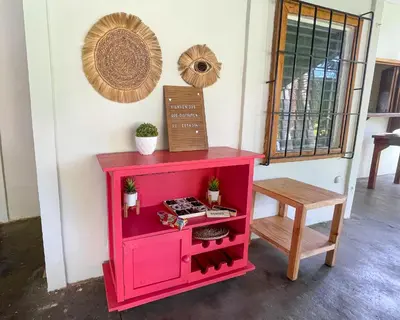 a pink cabinet next to a table and a stool at Casa De Playa El Encanto in El Porvenir