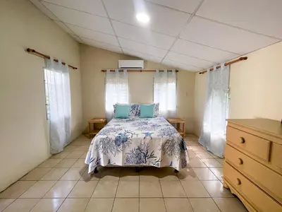 a bedroom with a bed in a room with windows at Casa De Playa El Encanto in El Porvenir