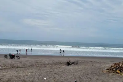 a group of people standing on a beach at Hermosa Casa de Playa DejaBlue SV in La Libertad