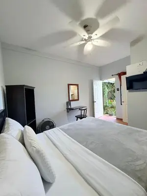 a bedroom with a large bed with a ceiling fan at Los Portones de Ataco in Concepción de Ataco