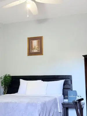 a bedroom with a white bed with a black headboard at Los Portones de Ataco in Concepción de Ataco