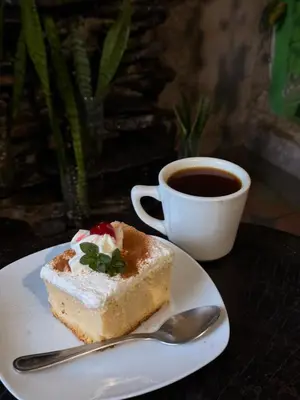 a piece of cake on a plate next to a cup of coffee at Los Portones de Ataco in Concepción de Ataco