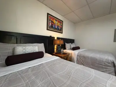 a bedroom with two beds and a table with a lamp at Los Portones de Ataco in Concepción de Ataco