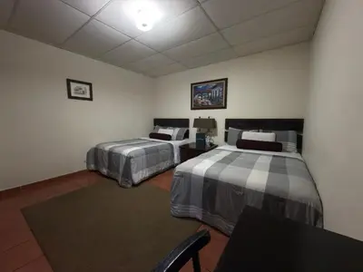 a room with two beds and a table at Los Portones de Ataco in Concepción de Ataco