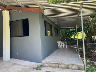 a porch of a house with a chair and a table at El mangal B&B in Suchitoto