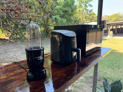 a microwave and a blender on a wooden table at El mangal B&B in Suchitoto