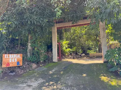 an entrance to a building with a sign in front at El mangal B&B in Suchitoto