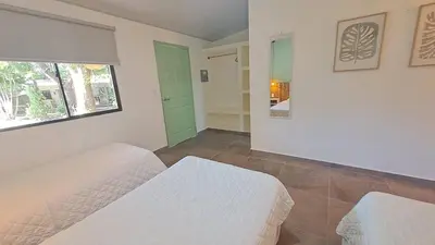 a bedroom with two white beds and a window at Hotel Zelen in Tamanique
