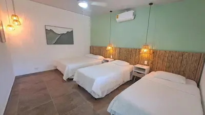 a hotel room with two beds and two lamps at Hotel Zelen in Tamanique