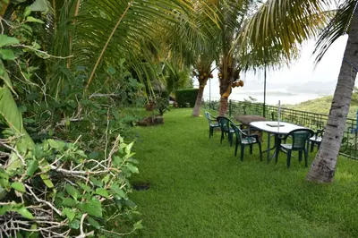 a table and chairs on the grass near the ocean at The Mayan Grouper in Suchitoto