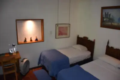 a bedroom with two beds and a mirror on the wall at The Mayan Grouper in Suchitoto