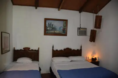 two beds in a room with white walls at The Mayan Grouper in Suchitoto