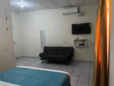 a room with a couch and a flat screen tv at Chalchuapa, Santa Ana La Casa de Sussy, El Salvador in Chalchuapa