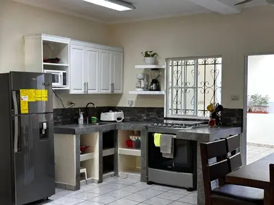 a kitchen with white cabinets and a black refrigerator at Chalchuapa, Santa Ana La Casa de Sussy, El Salvador in Chalchuapa