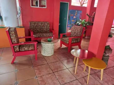 a room with colorful chairs and tables and a table at MARDEORO BEACH HOUSE in Barra de Santiago