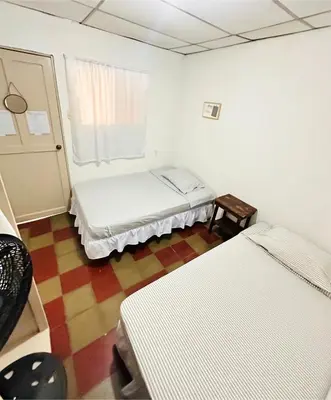 a room with two beds and a window at Hostal Villa Marta in Santa Ana