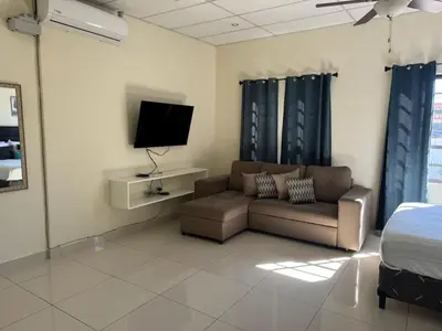 a living room with a couch and a tv at Merliot, Sta Tecla Frente Cto Comer La Plaza Merliot in Nueva San Salvador