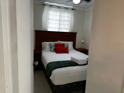 a bedroom with a bed with red pillows and a window at Merliot, Sta Tecla Frente Cto Comer La Plaza Merliot in Nueva San Salvador