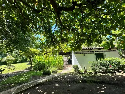 a white building in a yard with a tree at Surf City Town House in La Libertad
