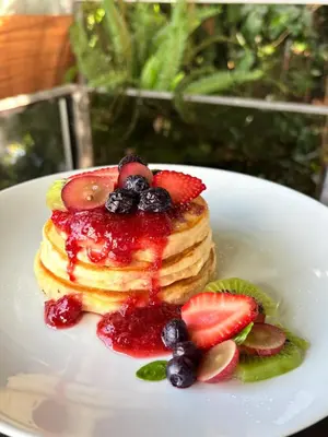 a plate of pancakes with berries and fruit sauce at Bosko cerro verde in Lomas de San Marcelino