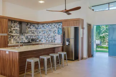 a kitchen with a stainless steel refrigerator and stools at Ayanna Beach Front in La Libertad