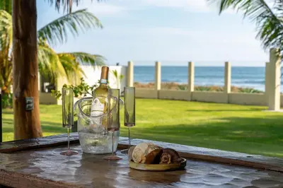 a table with a bottle of wine and a bread at Ayanna Beach Front in La Libertad