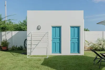 a white house with blue doors and a ladder at Ayanna Beach Front in La Libertad