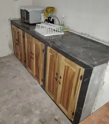 a kitchen counter with a microwave on top of it at Casita Escondida- El Salvador in La Libertad