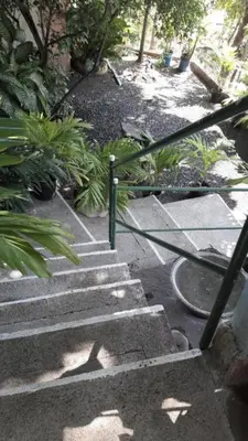 a set of concrete stairs with a green railing at Casita Escondida- El Salvador in La Libertad