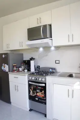 a kitchen with a stove and a microwave at Casa flores Residencial Privada Nueva San miguel in San Miguel