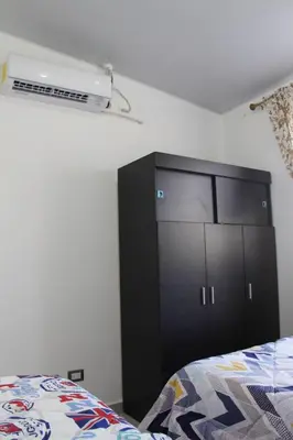 a bedroom with a black cabinet and a bed at Casa flores Residencial Privada Nueva San miguel in San Miguel