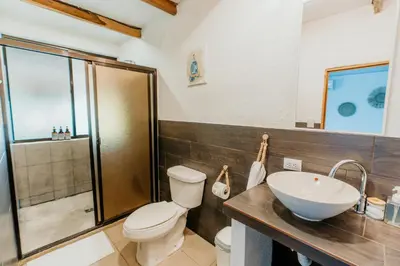 a bathroom with a toilet and a sink and a shower at NAIA - Miravalle in Sonsonate