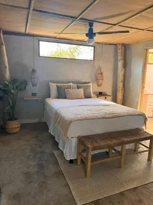 a bedroom with a large bed and a window at NAIA - Miravalle in Sonsonate