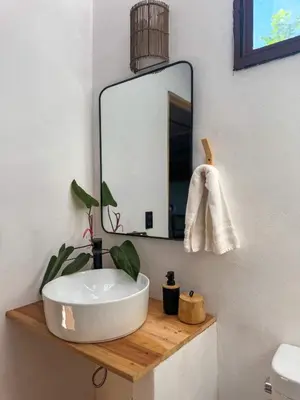 a bathroom with a sink and a mirror at NAIA - Miravalle in Sonsonate