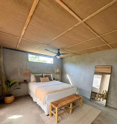 a bedroom with a large bed and a mirror at NAIA - Miravalle in Sonsonate