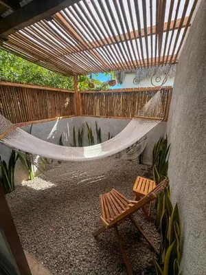 a porch with a hammock and a bench and a fence at NAIA - Miravalle in Sonsonate