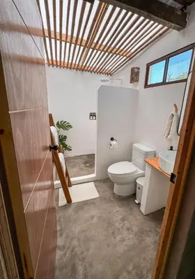 a bathroom with a toilet and a sink at NAIA - Miravalle in Sonsonate