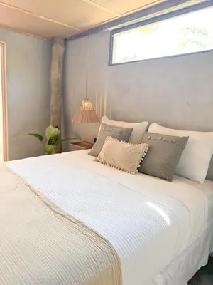 a large white bed in a room with a window at NAIA - Miravalle in Sonsonate