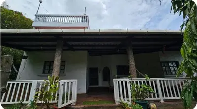 a house with a white porch and a balcony at Jaco Mizata Beach and River in La Libertad