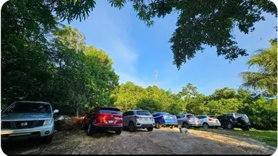 a row of cars parked in a parking lot at Jaco Mizata Beach and River in La Libertad