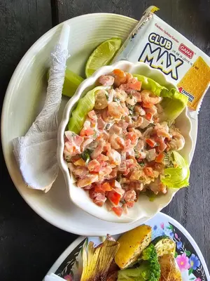 a bowl of shrimp salad on a plate with a bag of chips at Jaco Mizata Beach and River in La Libertad