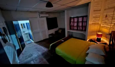 a bedroom with a bed and a room with a television at Jaco Mizata Beach and River in La Libertad