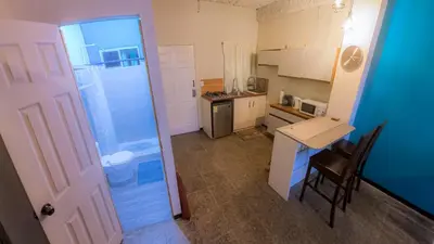 a small kitchen with a table and a door at Sunset View - Mini Loft in La Libertad