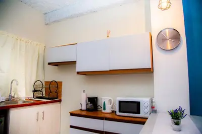 a kitchen with white cabinets and a microwave at Sunset View - Mini Loft in La Libertad