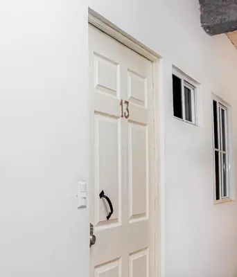 a white door with a black handle next to a wall at Sunset View - Mini Loft in La Libertad