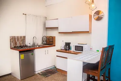 a small kitchen with a table and a microwave at Sunset Views - Acogedor con vista al mar in La Libertad