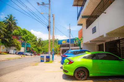 a green car parked next to a building on a street at Sunset Views - Acogedor con vista al mar in La Libertad
