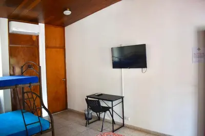 a room with a table and a tv on a wall at Volcano Hostal y Restaurante in San Salvador