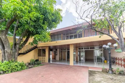 an exterior view of a building with trees at Volcano Hostal y Restaurante in San Salvador